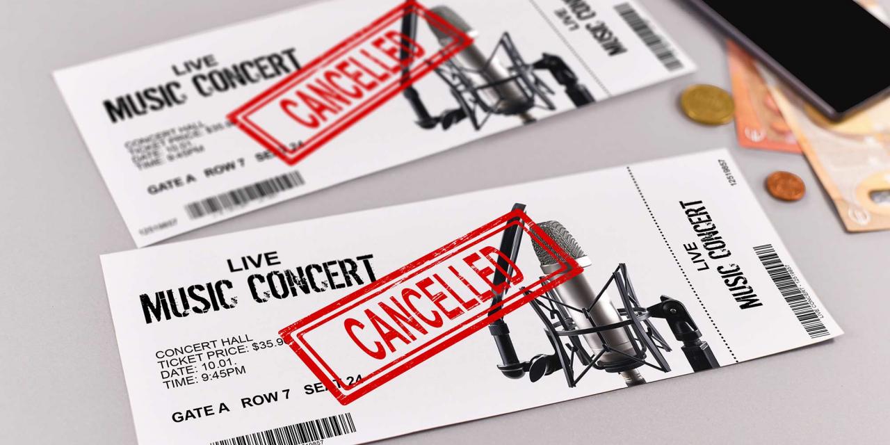 Musiktickets mit dem Aufdruck "Cancelled", daneben Geld und Smartphone