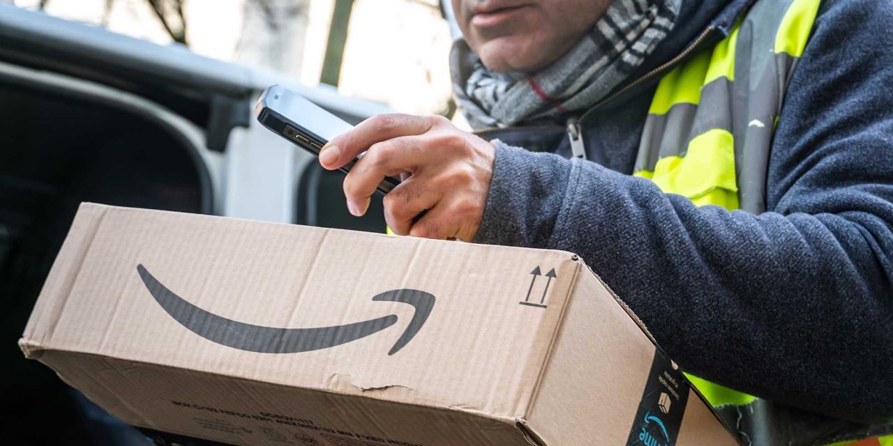 Paketdienst Zusteller scannt Code eines Amazon Paketes ein