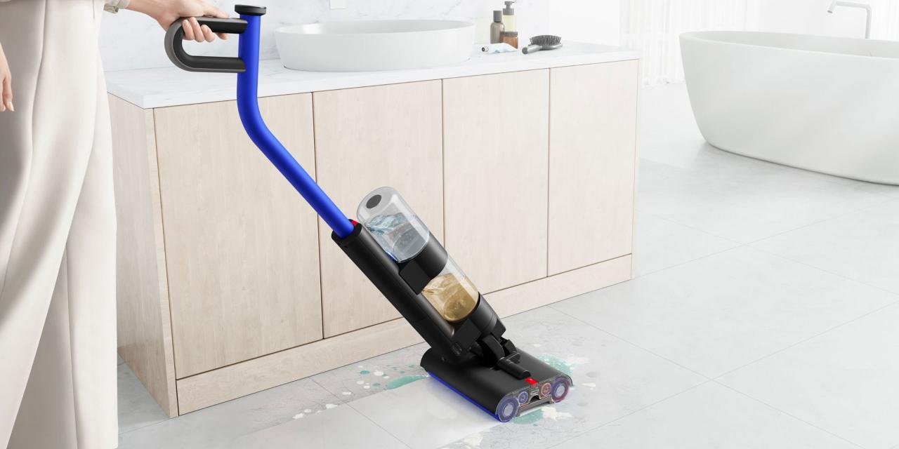 Person fährt mit Akkuwischer über Badezimmerfliesen, Badezimmerkasten mit Waschbecken und Badewanne im Hintergrund