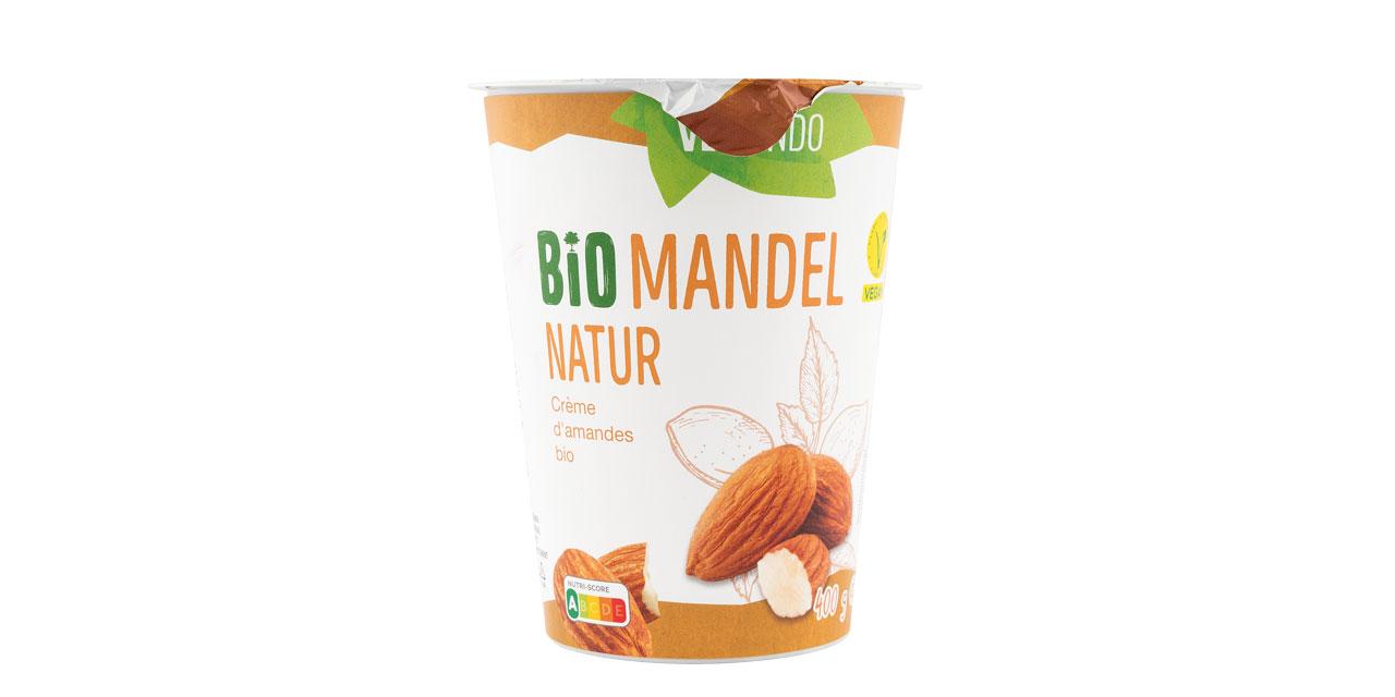 Ein Becher Bio Mandel Natur Joghurtersatz der Marke Vermondo mit groß abgebildeten Mandeln.