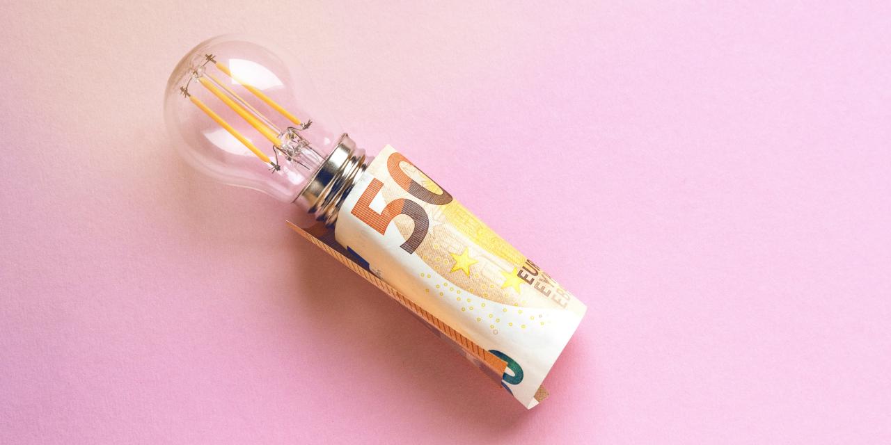 Glühbirne in einer Fassung aus Geld