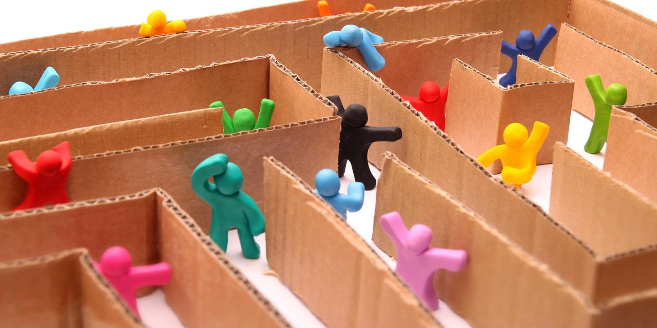 Bunte Figuren suchen den Weg durch ein Labyrinth