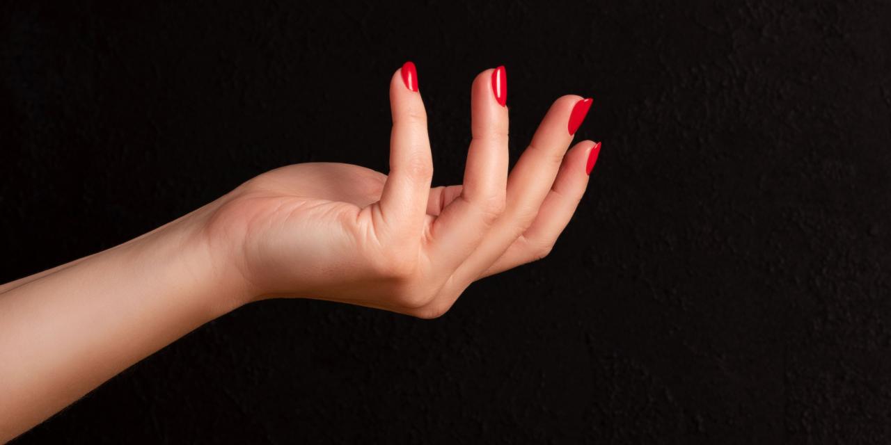 Frauenhand mit rotem Nagellack vor schwarzem Hintergrund