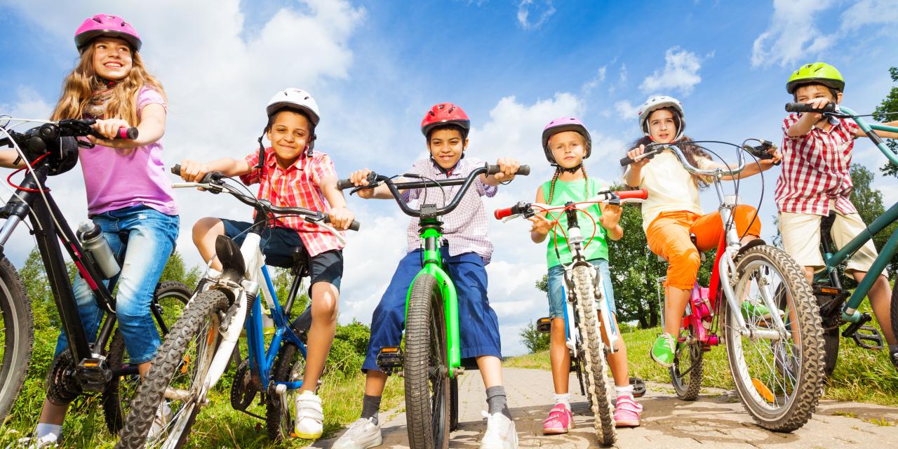 Mehrere Kinder am Fahrrad, alle tragen Helm