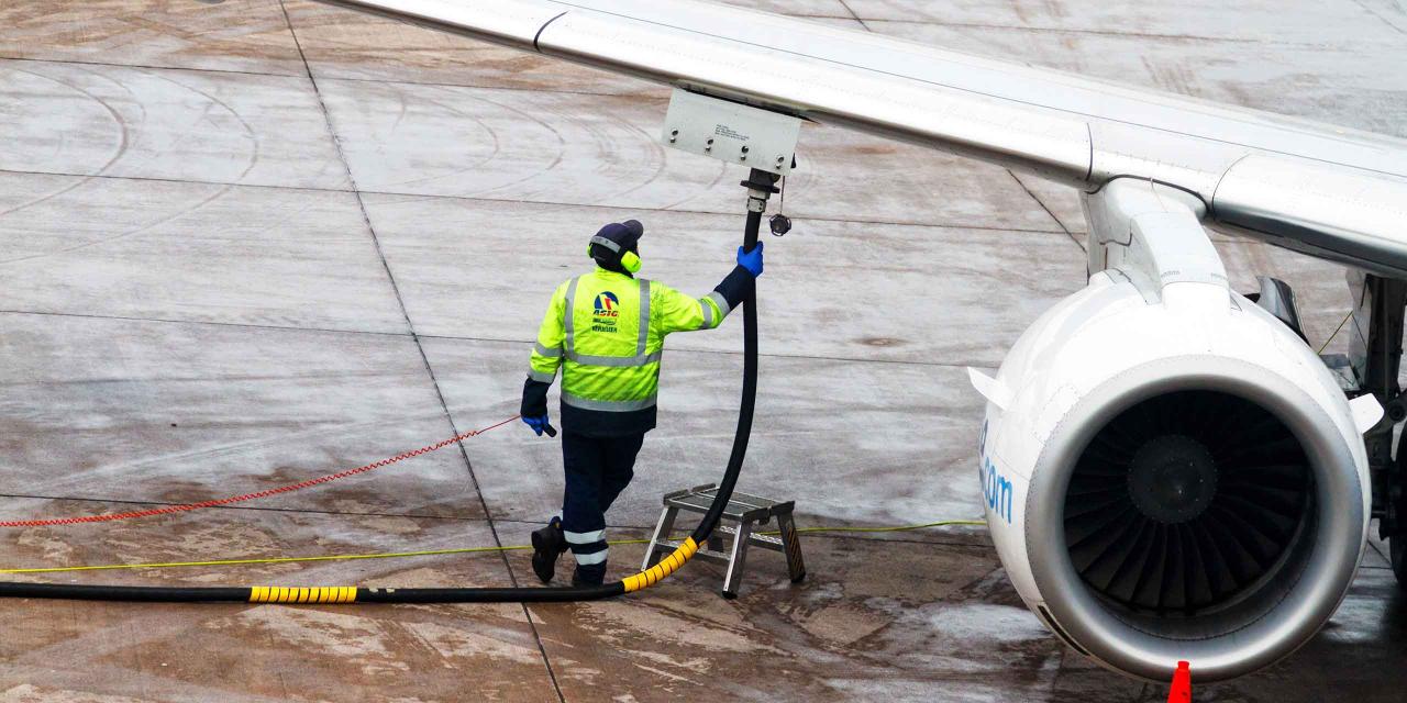 Mann betankt ein Flugzeug mit Kerosin