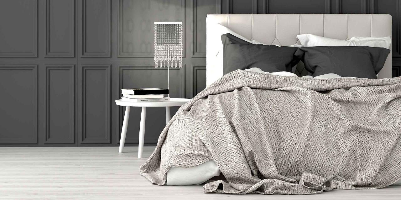 Boxspringbett in Schlafzimmer mit grauem Überwurf