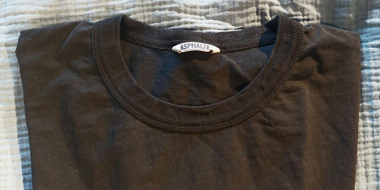 Zusammengelegtes, schwarzes T-Shirt der Marke Asphalte