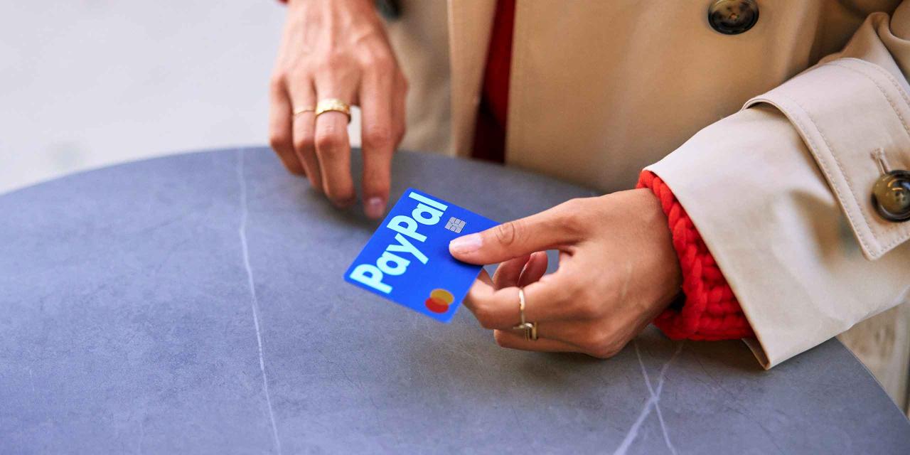 Frau hält eine PayPal-Kreditkarte in der Hand