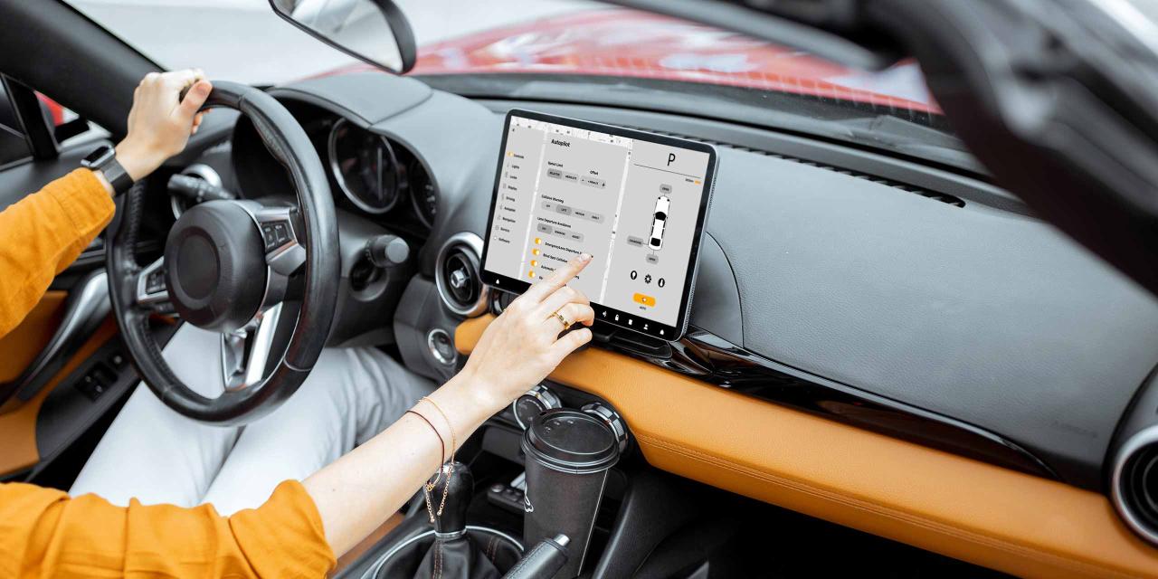 Im Auto: Lenkerin bedient das Display neben dem Lenkrad