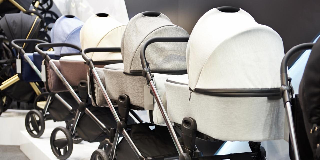 Eine Reihe von Kinderwagen steht im Ausstellungsraum eines Geschäftes