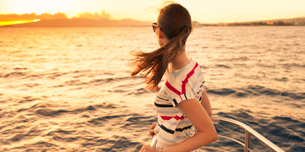 junge Frau am Bug eines Schiffes
