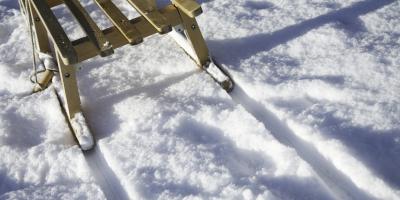 Rodel auf einer Schneepiste