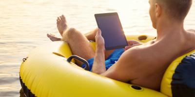 Mann im Schlauchboot mit Tablet in der Hand