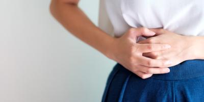 Frau hält sich den Unterbauch