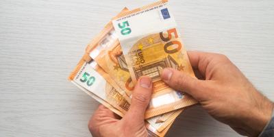 Zwei Hände halten einige 50-Euro-Scheine