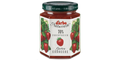 Marmeladenglas mit sechseckigem Querschnitt, weißes Etikett mit abgebildeten Erdbeeren, schwarzer Schraubverschluss