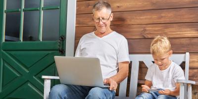 Großvater Enkel sitzen auf einer Bank Laptop Smartphone