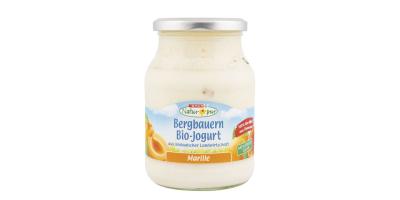 Ein Glas Spar Natur Pur Bergbauern Bio Joghurt der Sorte Marille mit hellblauem Etikett vor weißem Hintergrund.