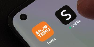 Die Apps von Temu und Shein sind auf einem Handydisplay abgebildet, ein Finger schwebt leicht über der App von Shein. 
