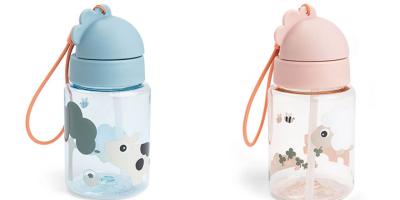 Das Bild zeigt zwei Kindertrinkflaschen nebeneinander vor weißem Hintergrund. Beide Flaschen sind transparent und mit niedlichen Tiermotiven bedruckt. Links ist eine Flasche mit blauem Deckel und orangefarbener Trageschlaufe, rechts eine ähnliche Flasche mit rosafarbenem Deckel und ebenfalls orangefarbener Schlaufe. Beide verfügen über einen integrierten Trinkhalm und einen kindgerechten Klappverschluss.