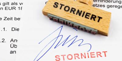 Holzstempel mit der Aufschrift "Storniert" auf einem unterschriebenen Vertrag
