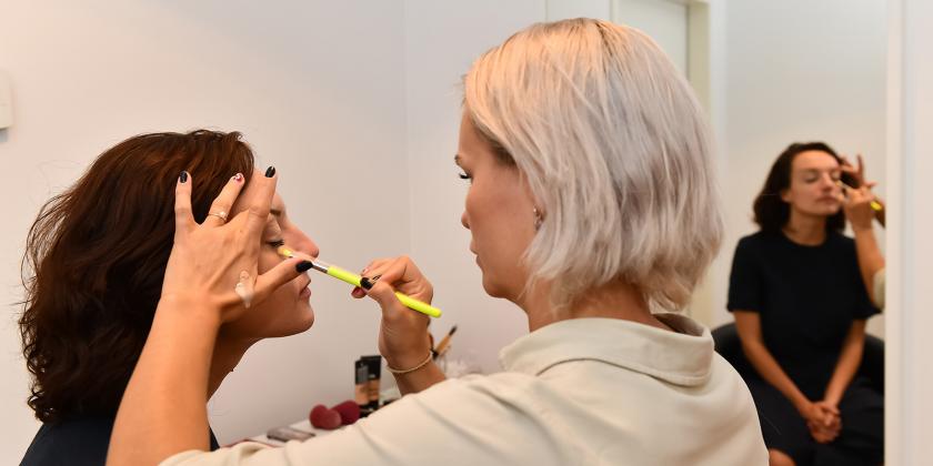 Eine Dame wird in der Maske geschminkt.