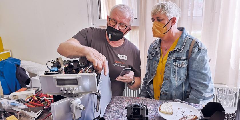 Mann und Frau reparieren Kaffeevollautomaten