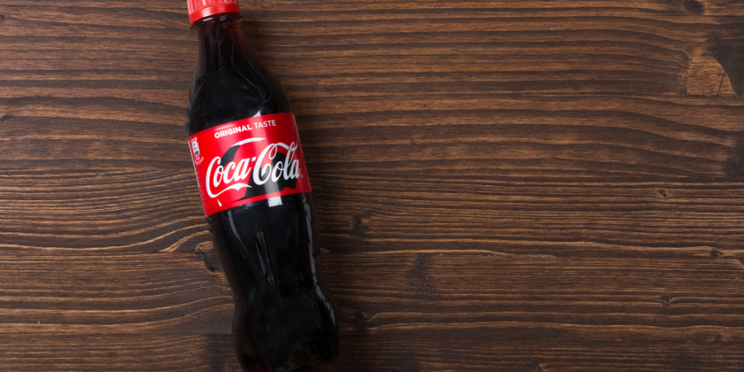 Coca Cola Flasche vor Holzhintergrund