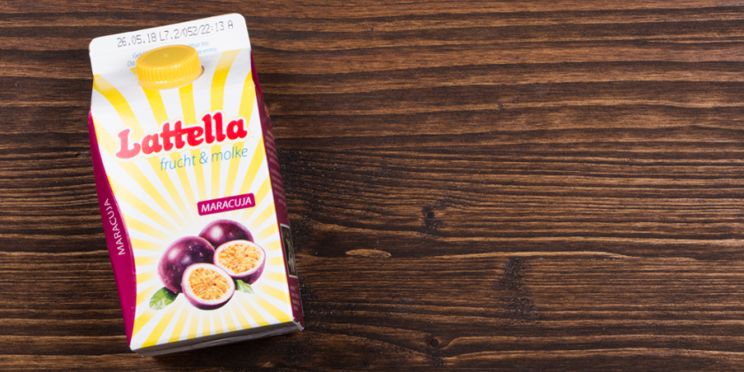 Latella-Molkegetränk vor Holzhintergrund