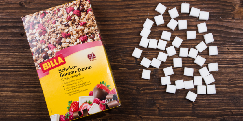 Schoko-Beeren-Müsli mit Zuckerstücken vor Holzhintergrund