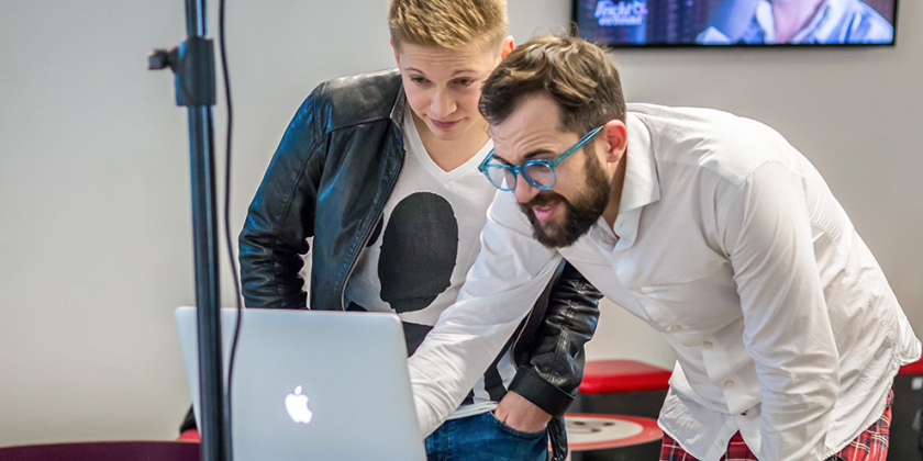 Sänger Florian Ragendorfer und der Fotograf schauen auf einen Laptop-Screen, ob ein gutes Fotos dabei ist.