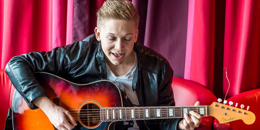 Florian Ragendorfer singt mit Gitarre in der Hand.