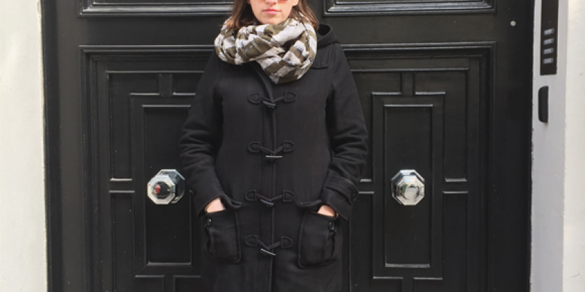 Frau vor einer schwarzen Eingangstür in Model-Pose.