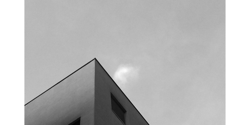 Gebäudespitze eines Wohnhauses in schwarz-weiß.