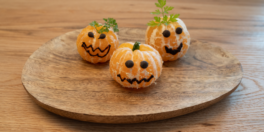 Geschälte Mandarinen mit Gesicht auf Teller