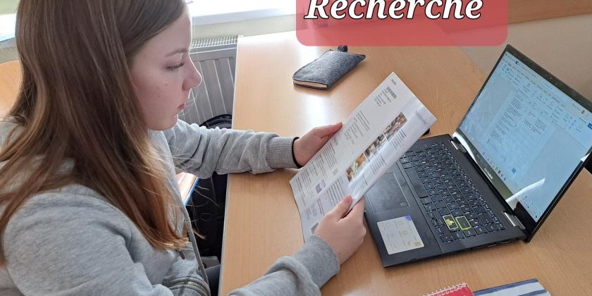 Schülerin am Tisch vor Laptop und KONSUMENT-Heft