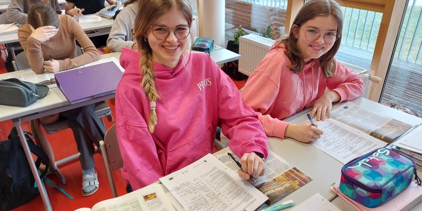 Schülerinnen am Schreibtisch mit KONSUMENT