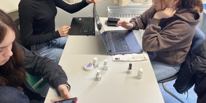 Schülerinnen am Schreibtisch mit Laptops und Nagellacken