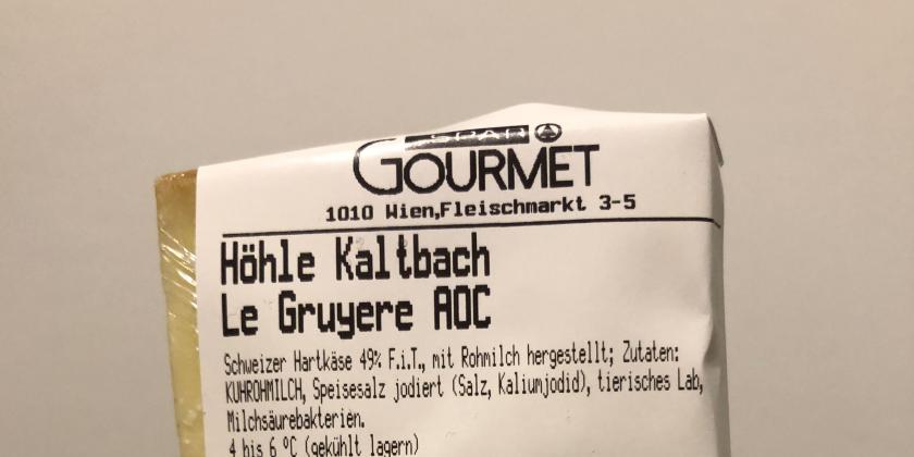 Le Gruyere Käse mit Aktionsersparnis: verpackter Käse mit Aufschrift der Bezeichnung des Produkts