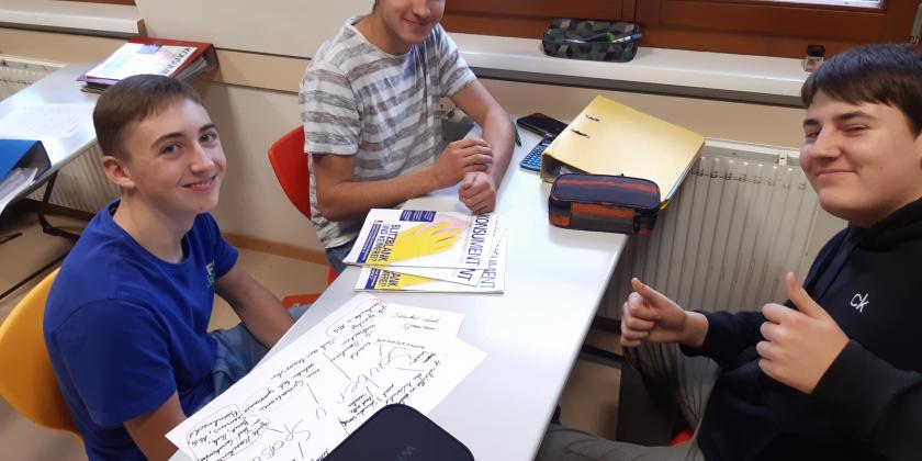 3 Schüler am Schreibtisch mit KONSUMENT