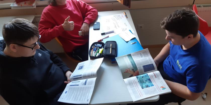 3 Schüler am Schreibtisch mit KONSUMENT