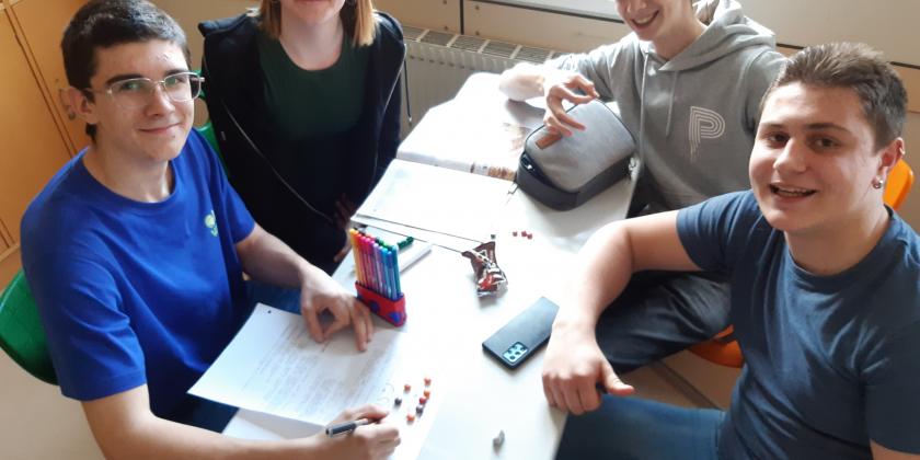 4 Schüler:innen am Schreibtisch mit KONSUMENT