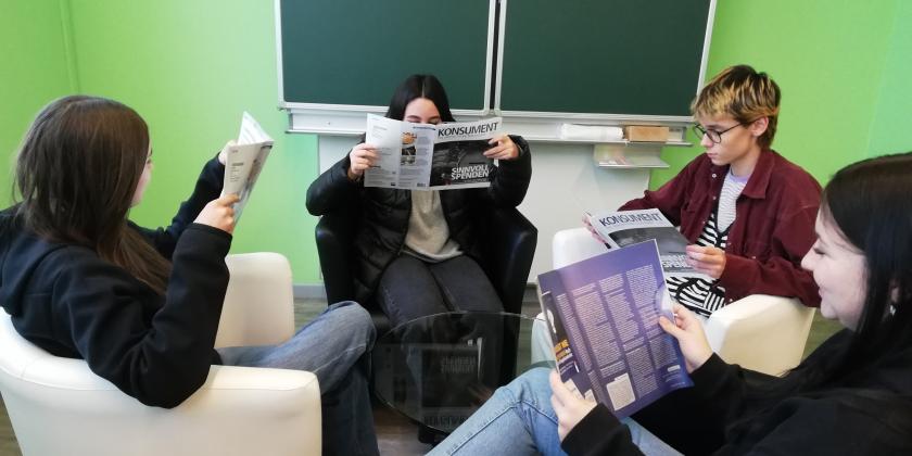 Schüler:innen in Sesseln KONSUMENT lesend
