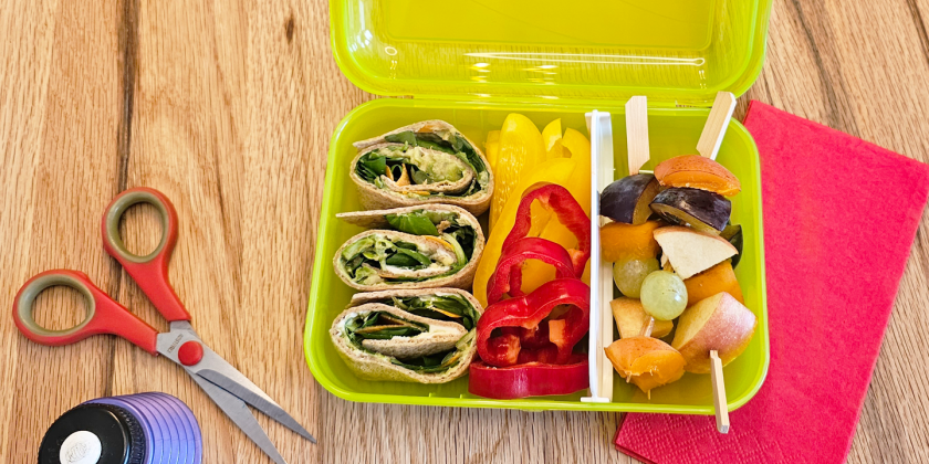 Vollkornwraps mit Avocado, Frischkäse, Salat und Karottenstreifen; Snackgemüse und Obstspieße