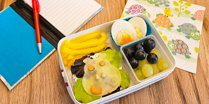 Vollkornbrot mit Frischkäse, Salat und Käsescheiben-Nilpferd; Ei, Paprika und Weintrauben