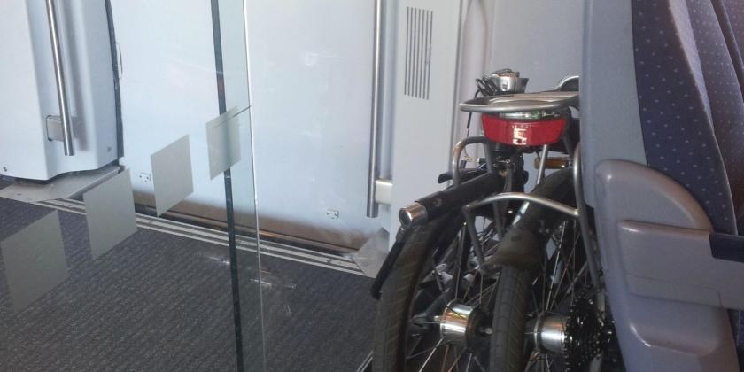 Faltrad im ICE der Deutschen Bahn zwischen Abteiltür aus Glas und Sitz
