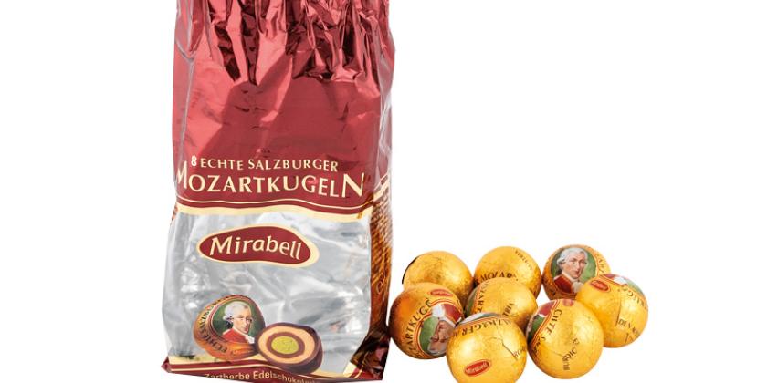 Mirabell Mozartkugeln - leere geöffnete Packung und daneben 8 Mozartkugeln