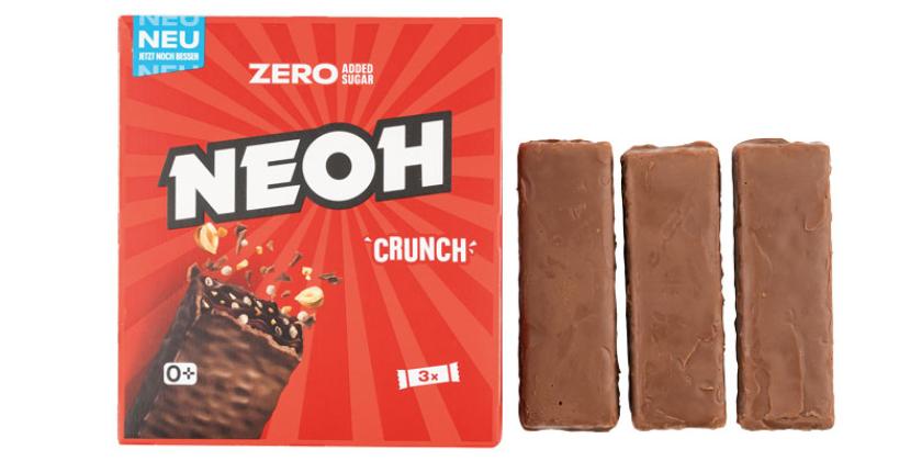Drei ausgepackte NEOH Crunch Riegel neben der Kartonverpackung in rotem Design vor weißem Hintergrund.