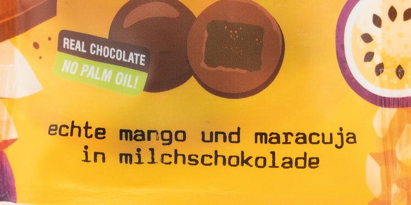 Die Auslobung &amp;quot;echte Mango und Maracuja in Milchschokolade&amp;quot; in schwarzer Schrift auf gelbem Hintergrund.