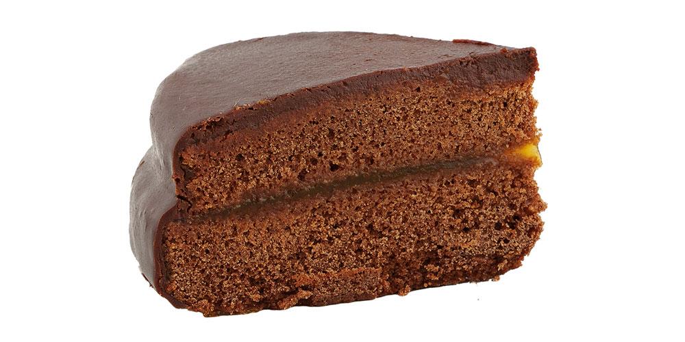 Sachertortenstück von der Seite vor weißem Hintergrund